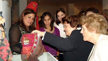 Mrs Widad Kawar explaining an object from the exhibition to HRH  Princess Rajwa bint Ali and her daughter.